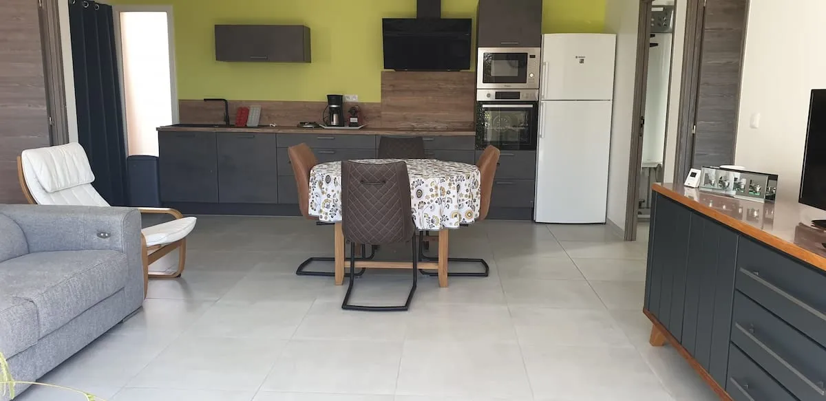 Espace de vie avec cuisine ouverte équipée, coin repas et salon