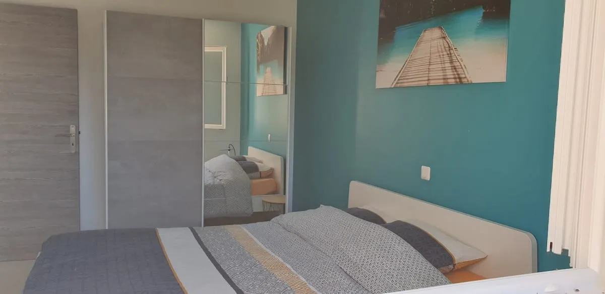 Chambre parentale avec lit queen size, mur d'accent bleu canard