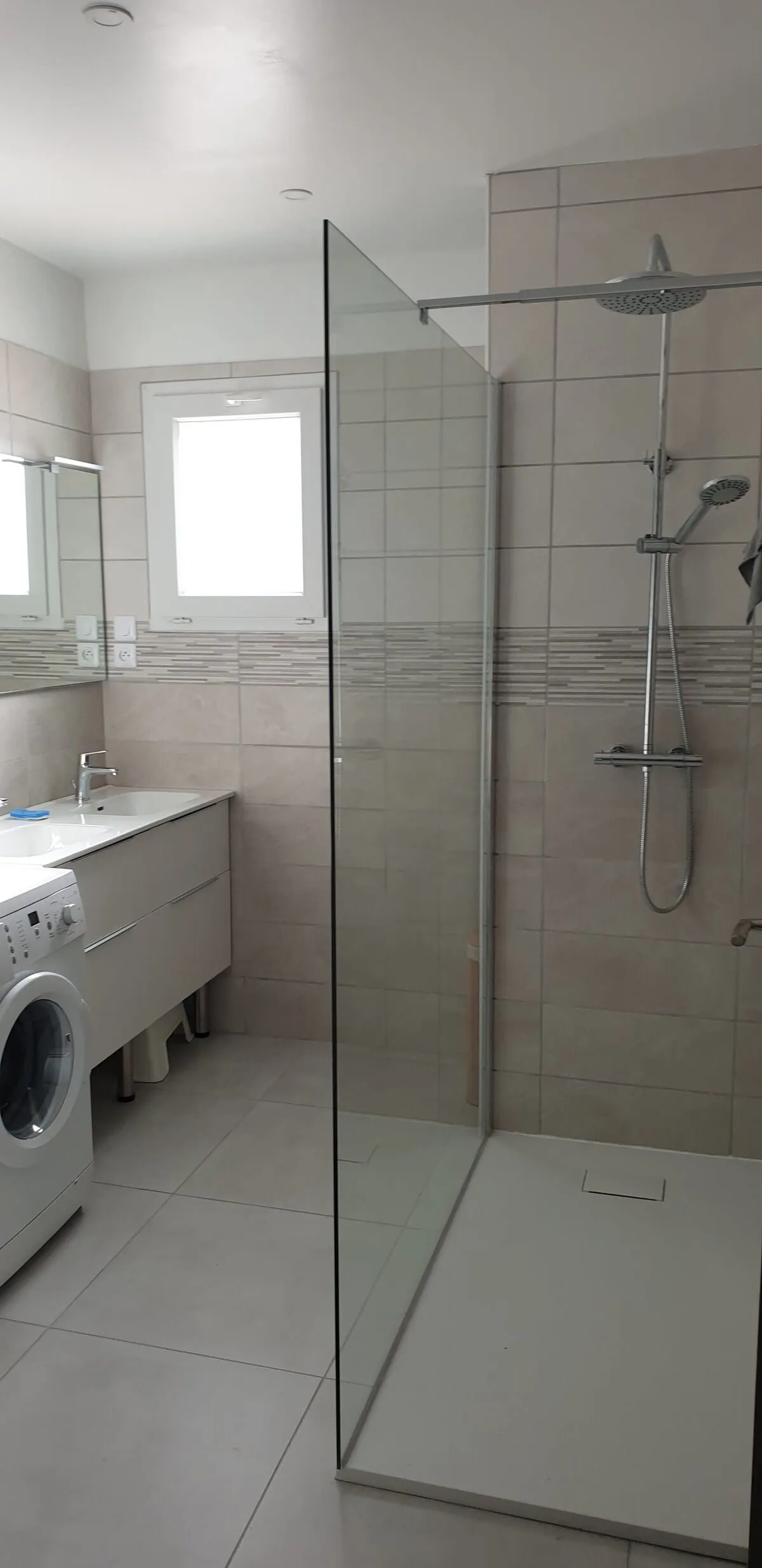 Salle de bain spacieuse avec douche à l'italienne, double vasque et lave-linge